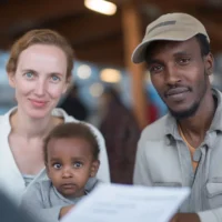 a-smiling-couple-with-a-young-child-sits-at-a-table