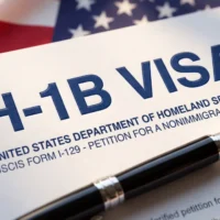 h1b-visa-application-on-a-desk-with-a-pen-and-an-american-flag-background