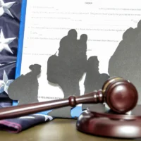 gavel-on-desk-with-silhouettes-of-people-and-american-flag-in-the-background