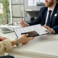 close-up-of-unrecognizable-woman-applying-for-visa-in-us-immigration-office-and-handing-documents